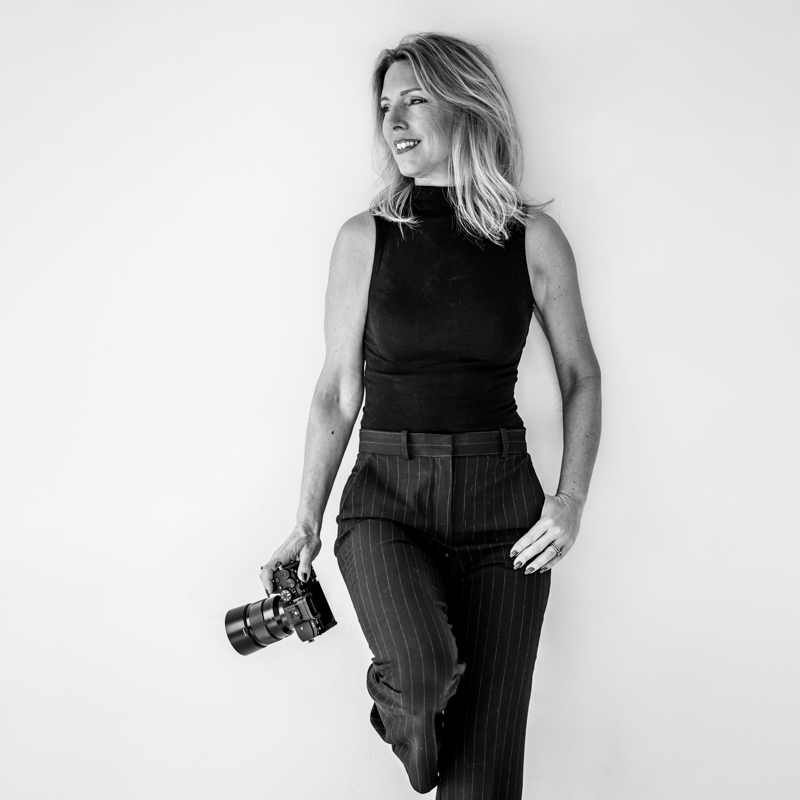 fotograaf Krista van den Akker leunt tegen muur